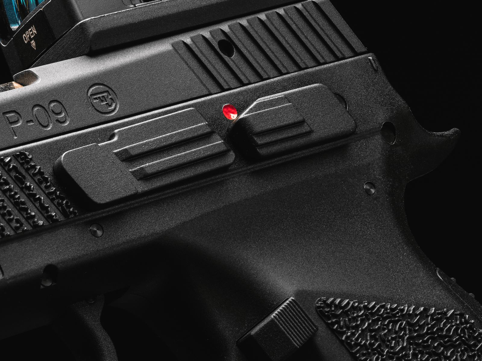 Nahaufnahme eines schwarzen Airsoft-Pistolen-Schlittens mit Textur und roter Markierung.