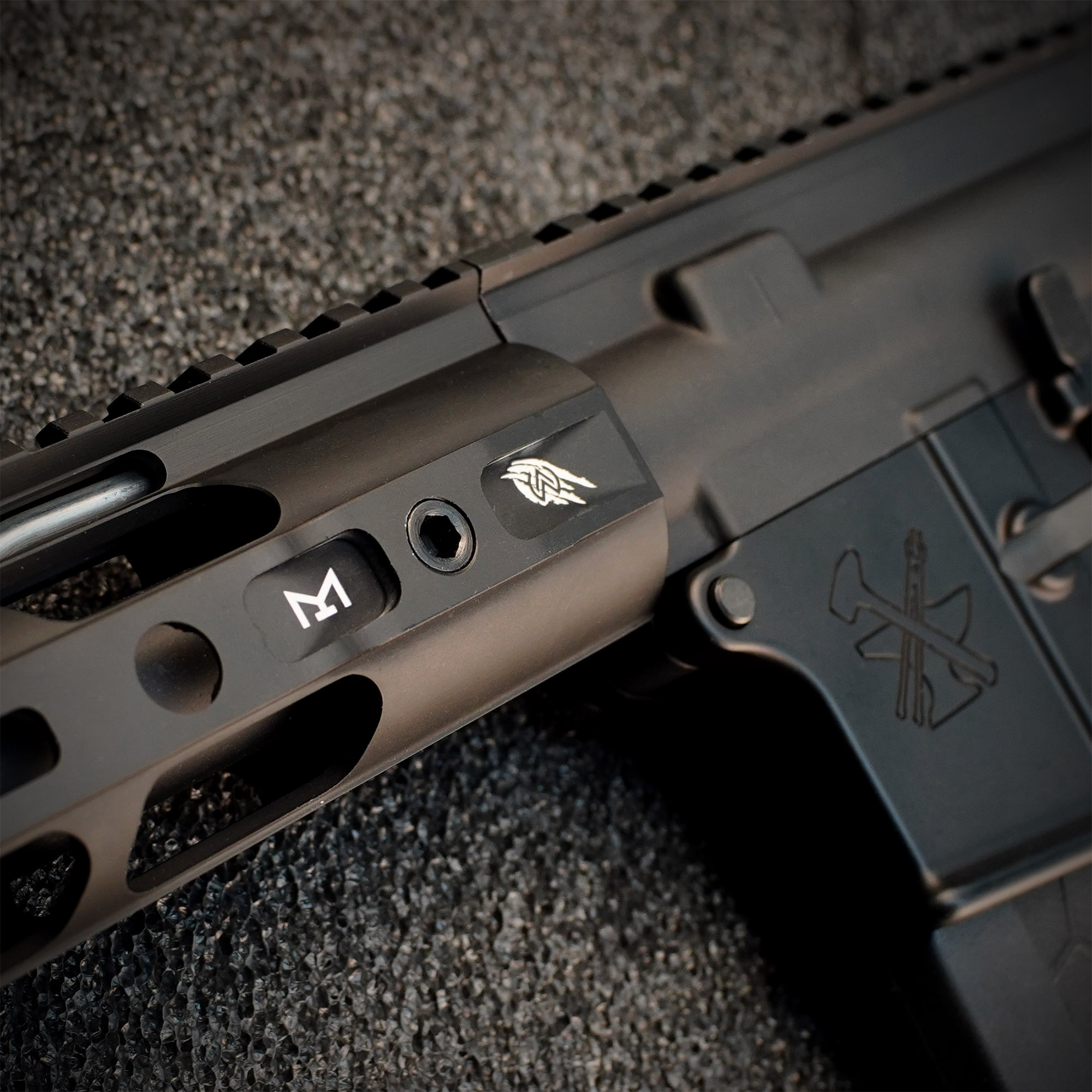 Wolverine Airsoft MTW Forged Series Gen 3 Semi-Only 10" - ab 18 Jahren Nahansicht eines schwarzen Airsoft-Handschutzes mit Gravuren auf strukturiertem Hintergrund.